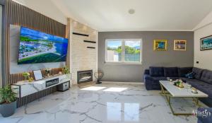 a living room with a blue couch and a tv at Holiday Home Nova Lux in Mostar