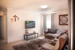 a living room with a couch and a clock on the wall at Jac-Marie guests accommodation in Tzaneen