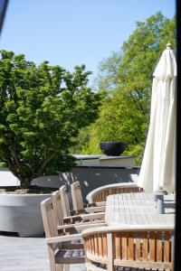 a row of chairs and a white umbrella at Chalet NATURTRAUM in Runkel