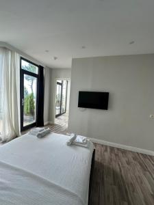 a bedroom with a bed and a flat screen tv at Villa Marnero in Grigoleti