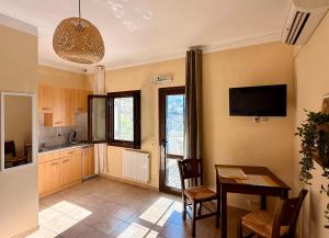 a kitchen and dining room with a table and a television at Sun Thavma Living studio psiloritis in Lístaros