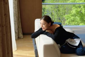 a woman is sitting on a couch at Hyatt Regency Beijing Wangjing in Beijing