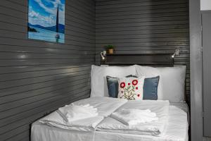 a bed with white sheets and pillows in a room at Villa My Garden in Zamárdi