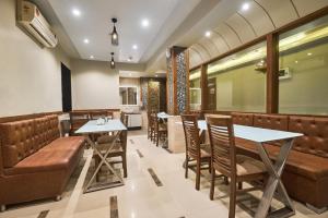 a restaurant with tables and chairs and a bar at Treebo Amber International Mumbai Airport T2 in Mumbai