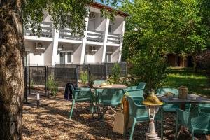 a group of tables and chairs under a tree at Villa My Garden in Zamárdi