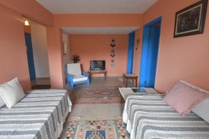 a room with two beds and a table and a chair at Mimas Garden Apartments in Karaburun
