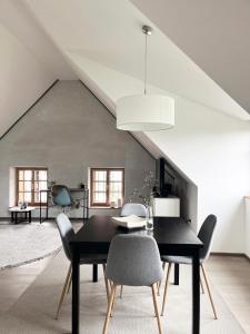 a dining room with a black table and chairs at Flösserhaus Steyr - Wohnen am Fluss in Steyr