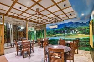 a restaurant with tables and chairs and a mural at Treebo Amber International Mumbai Airport T2 in Mumbai