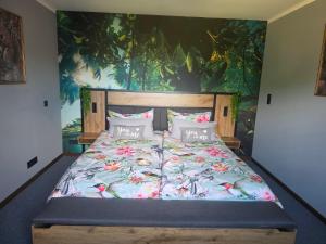 a bedroom with a large bed with a painting on the wall at Kleine Auszeit in Stolpe auf Usedom