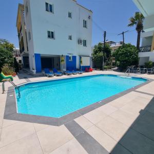 a swimming pool in front of a building at Renos Apartments in Polis Chrysochous