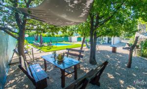 a picnic table and chairs in a park with a playground at Holiday Home Nova Lux in Mostar