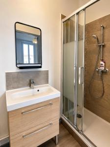 a bathroom with a sink and a shower with a mirror at Les Sources Vichy in Vichy +37 photos