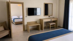 a room with a bedroom with a bed and a mirror at Mercans Bodrum Beach Hotel in Bodrum City