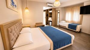 a hotel room with two beds and a tv at Mercans Bodrum Beach Hotel in Bodrum City +21 photos