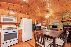 a kitchen with a table and a white refrigerator at Pet-Friendly Mountain Heaven - Hot Tub and Fire Pit in Blue Ridge
