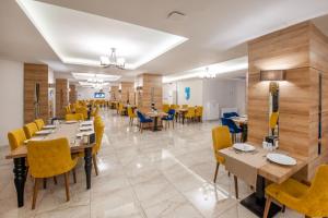 a dining room with tables and yellow chairs at ADIYAMAN PARK HOTEL in Adıyaman
