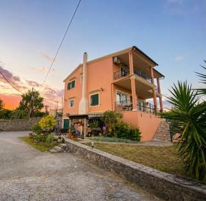 a pink house with a sunset in the background at Maison See View in Kontokali