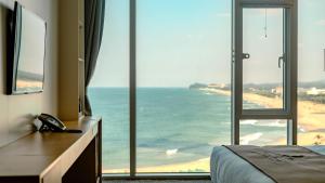 a bedroom with a view of the ocean at Potalaka Naksan Beach Wellness in Yangyang