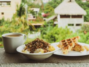 a table with two plates of food and a cup of coffee at Punta Kai Hotel & Hostal in Puerto Escondido