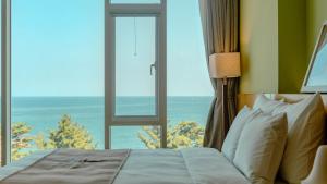 a bedroom with a bed and a large window at Potalaka Naksan Beach Wellness in Yangyang +18 photos
