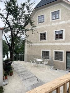 a table and chairs in front of a house at Flösserhaus Steyr - Wohnen am Fluss in Steyr