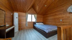 a bedroom with a bed in a wooden cabin at Jeju seawalk in Namwon