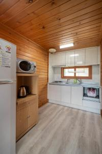 a kitchen with wooden walls and wooden floors and a refrigerator at Jeju seawalk in Namwon