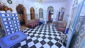 a living room with a couch and a checkerboard floor at aline hostel 2 in Chefchaouen +70 photos