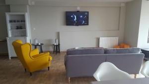 un salon avec un canapé et une chaise jaune dans l'établissement The Hostel, à Sierra Nevada