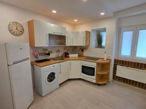 a kitchen with white appliances and a clock on the wall at Breece Hideaway in Piran