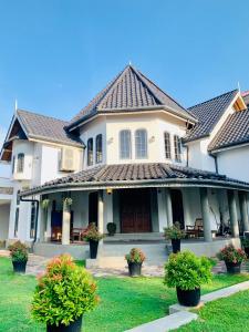 a large white house with potted plants in a yard at Airport Luxury Villa 65 - Negombo-Airport Transit Guest in Negombo +33 photos