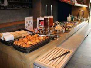 a buffet line with bread and pastries on it at ibis budget Rennes Rte Lorient in Rennes