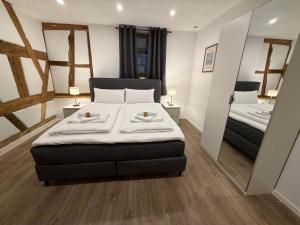 a bedroom with a large bed and two mirrors at JURAFLAIR Apartments in Lichtenfels
