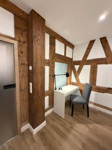 a desk and a chair in a room with wooden walls at JURAFLAIR Apartments in Lichtenfels