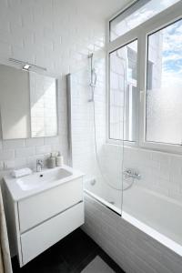 a white bathroom with a sink and a shower at Boho Apartments - 2 Bedrooms in Antwerp +16 photos