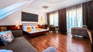 a hotel room with a bed and a couch at Hotel Tihany Átrium in Tihany