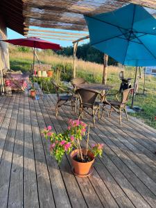 a wooden deck with a table and chairs and umbrellas at Mont Blanc in Meyrals