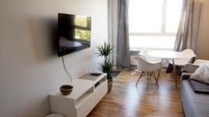 a living room with a couch and a tv on a wall at Apartamenty Grażyna Słodowiec in Warsaw