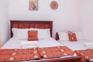 a bedroom with two twin beds with colorful pillows at Bamburi BnB in Mombasa