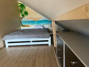 a bedroom with a bed with a painting on the wall at Apartament Na Wspólnej in Łeba