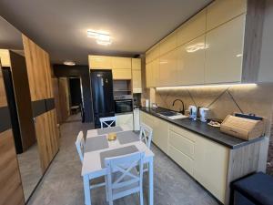 a kitchen with a table and chairs in a room at Apartament Na Wspólnej in Łeba