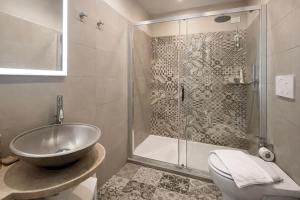 a bathroom with a shower and a sink and a toilet at Bramble Luxury Suites in Rome