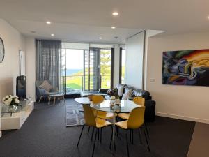 a living room with a table and yellow chairs at Newcastle Beach Escape in Newcastle
