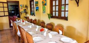 a long table with chairs and plates and flowers on it at Gîte Le Tropical in Rodrigues Island +49 photos