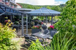 a patio with tables and chairs in a garden at Göbels Schlosshotel "Prinz von Hessen" in Friedewald