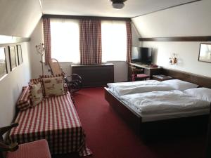 a hotel room with two beds and a desk at Gasthof Mitter in Haag