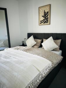 a bed with a white blanket and pillows on it at Olympus Pearl in Skotina