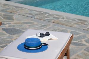 a hat and sunglasses on a table next to a pool at Taeri Sifnos in Sifnos