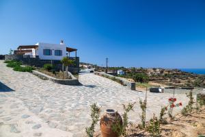 a stone road with a house and the ocean at Taeri Sifnos in Sifnos