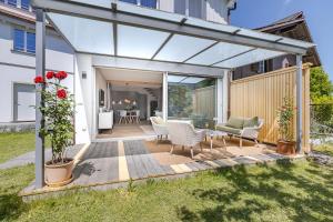 eine Terrasse mit Tisch und Stühlen auf einem Deck in der Unterkunft Eiche in Interlaken